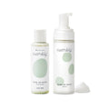 The Wipe-Up Wash Kit by Esembly Baby includes two bottles with white labels and green dot designs: one features Wipe Up Wash Concentrate with a screw cap, and the other is a Wipe Up Wash Foamer with a pump dispenser, perfect for organic foaming cleanser use with cloth wipes.