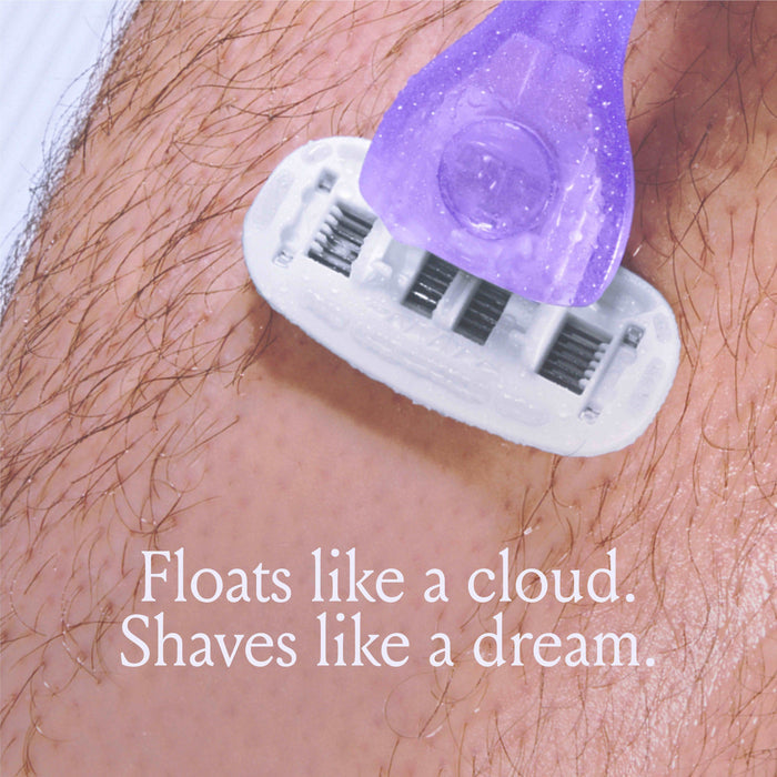 A close-up of a purple razor shaving hair on skin. The text reads, "Floats like a cloud. Shaves like a dream.