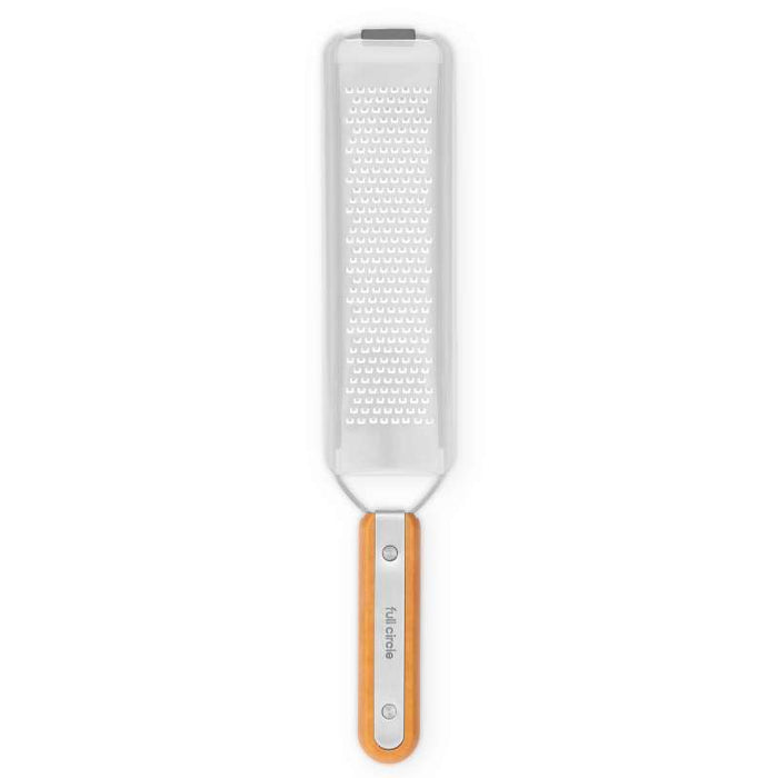 The Full Circle Zester is a rectangular kitchen tool with a stainless steel surface ideal for grating hard cheeses and citrus zest. It features a wooden handle with a metal loop for convenient hanging.