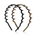 Two Kitsch Zig Zag Headbands are shown on a white background: one in black and the other with a brown tortoiseshell pattern. Made from recycled plastic, they have a wide-toothed design and non-slip grip for security.
