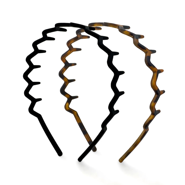 Two Kitsch Zig Zag Headbands are shown on a white background: one in black and the other with a brown tortoiseshell pattern. Made from recycled plastic, they have a wide-toothed design and non-slip grip for security.